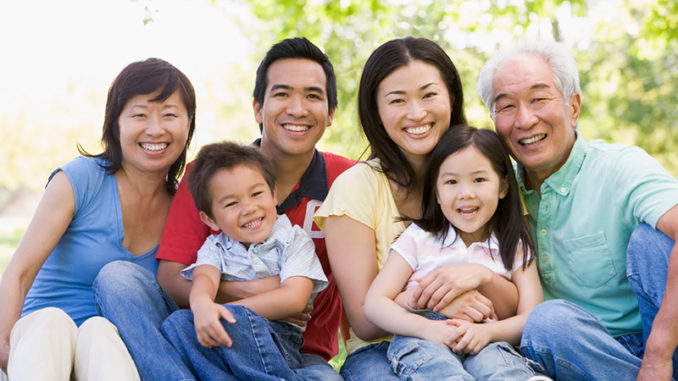 Extended family sitting outdoors smiling